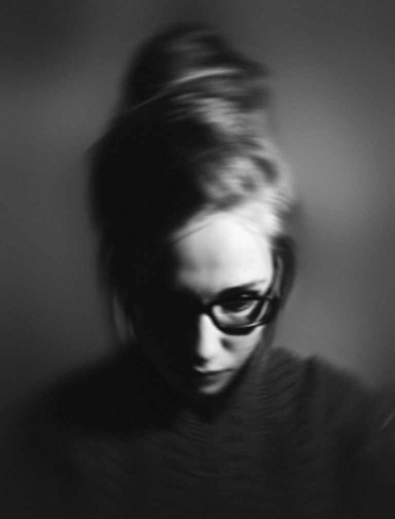blurry image of a lady that feels like she doesn't belong as she is suffering from imposter syndrome